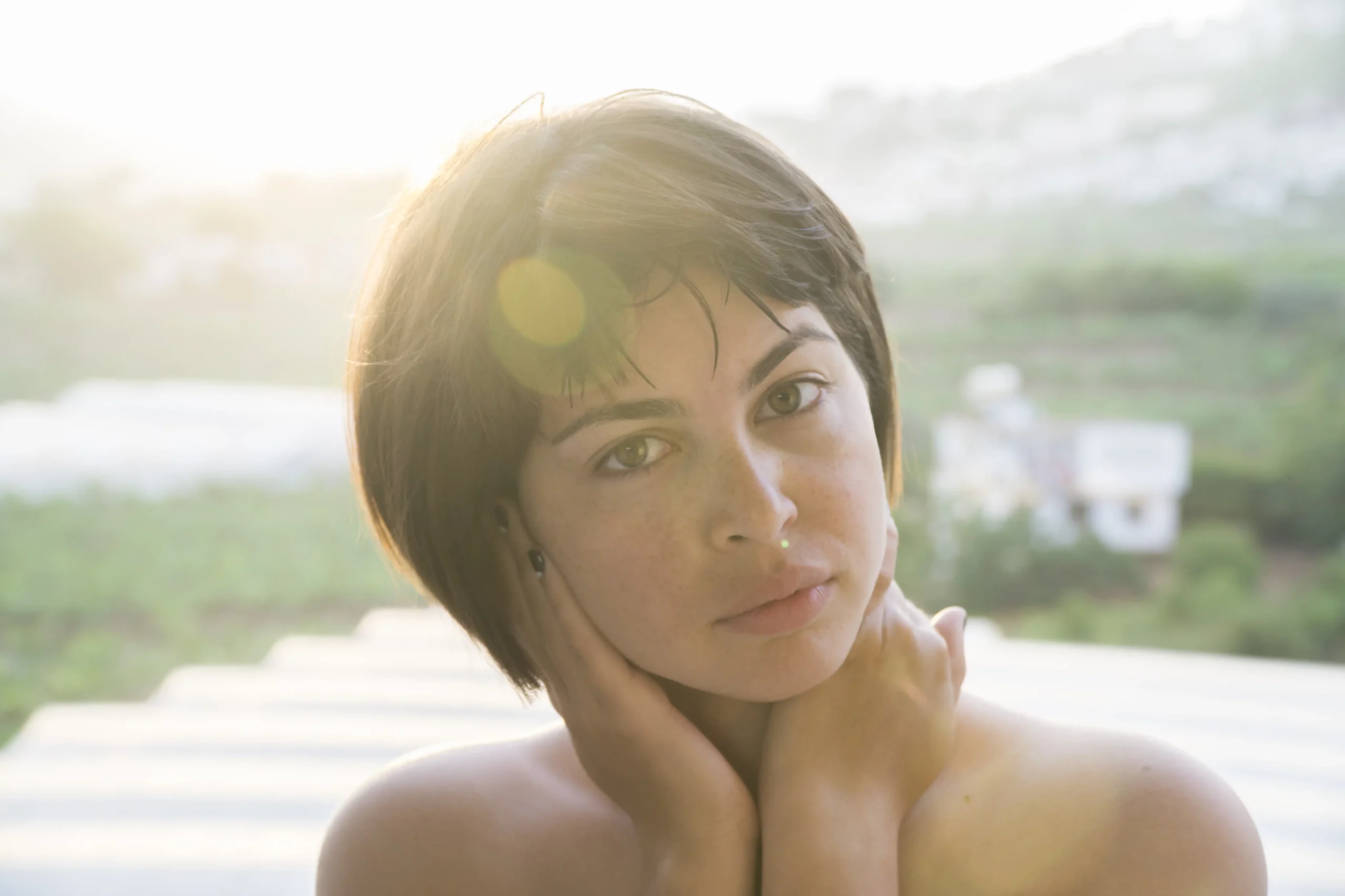 beautiful-woman-holding-her-neck-looking-daytime