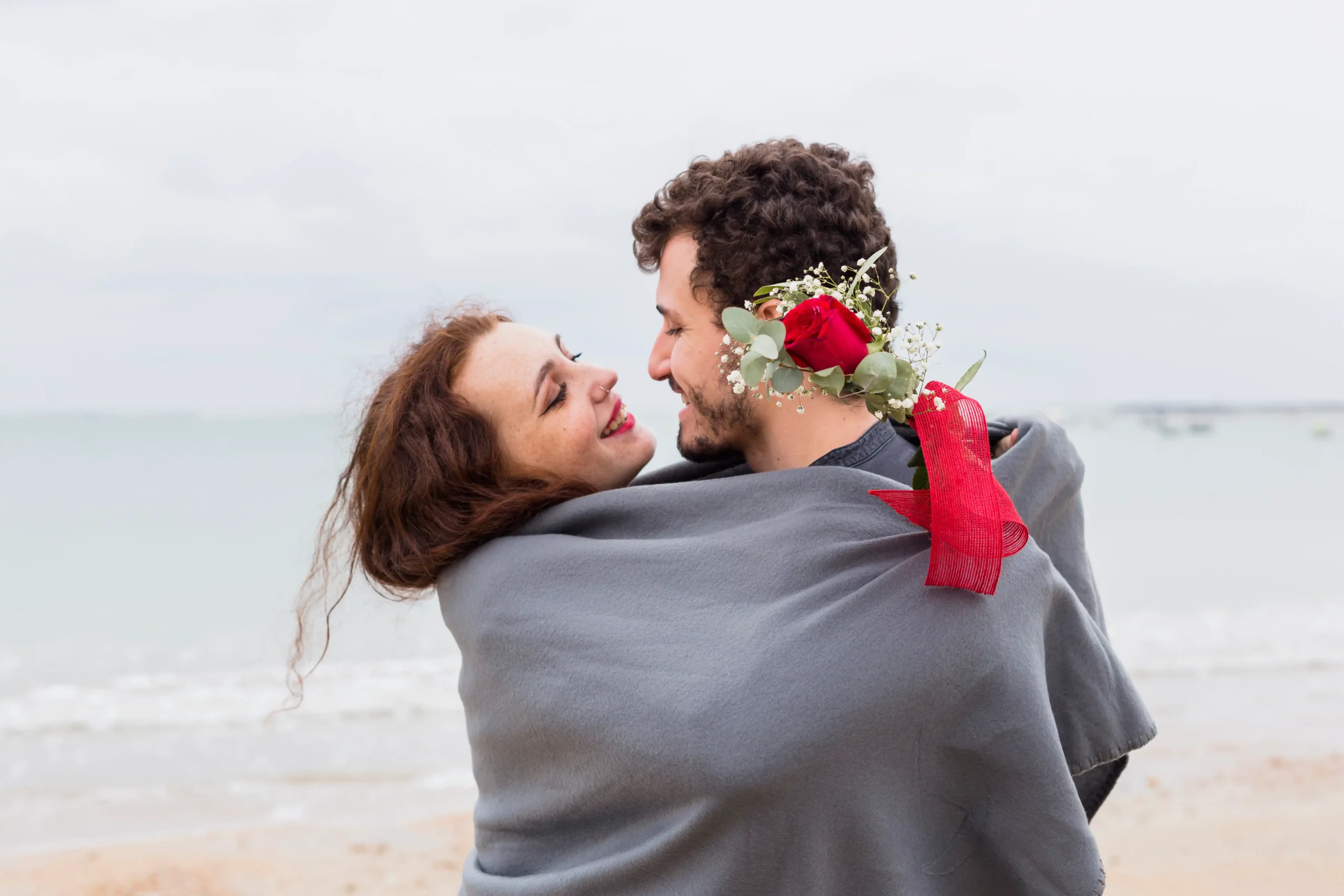 couple-blanket-hugging-sea-shore